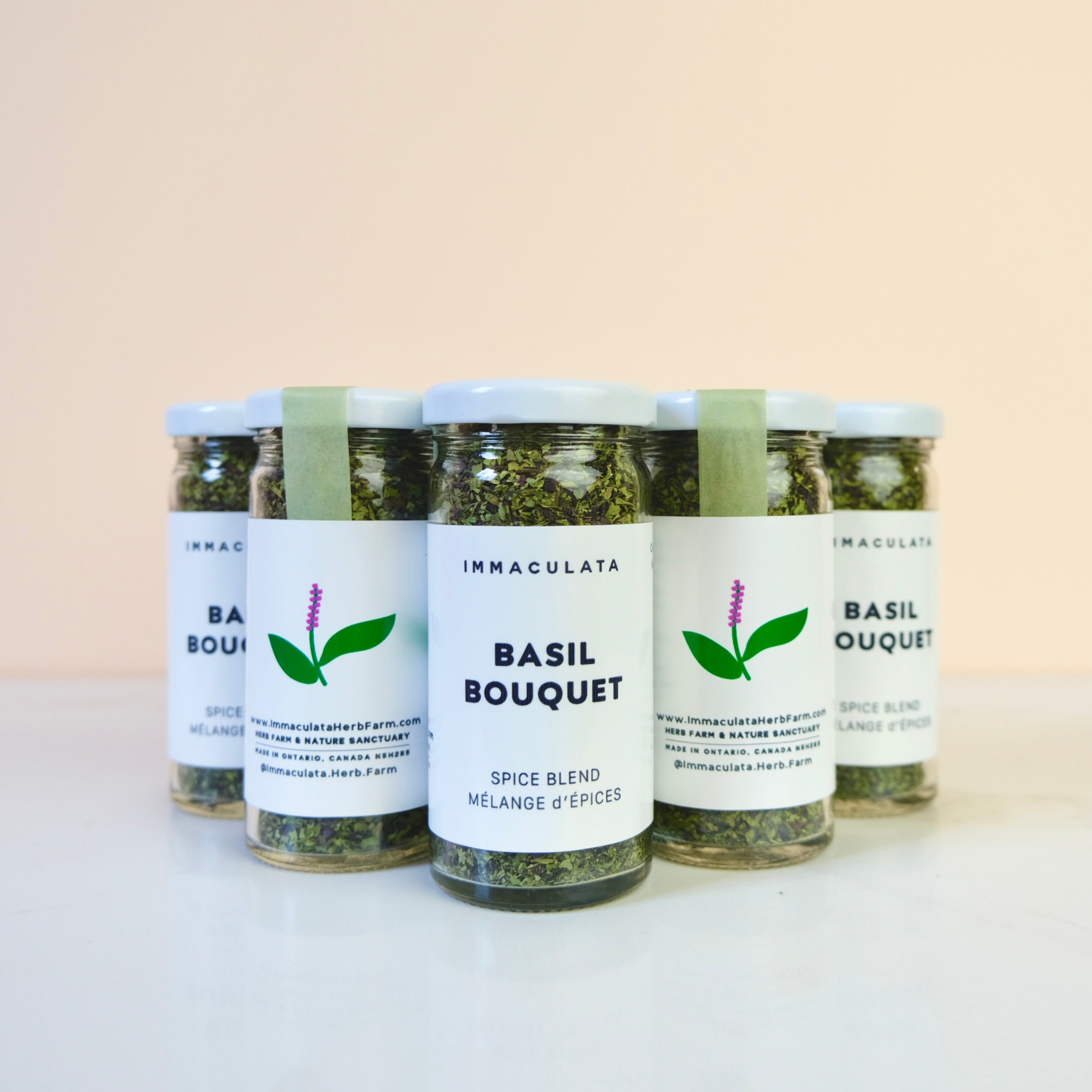 Four jars of Immaculata Basil Bouquet spice blend on a light background