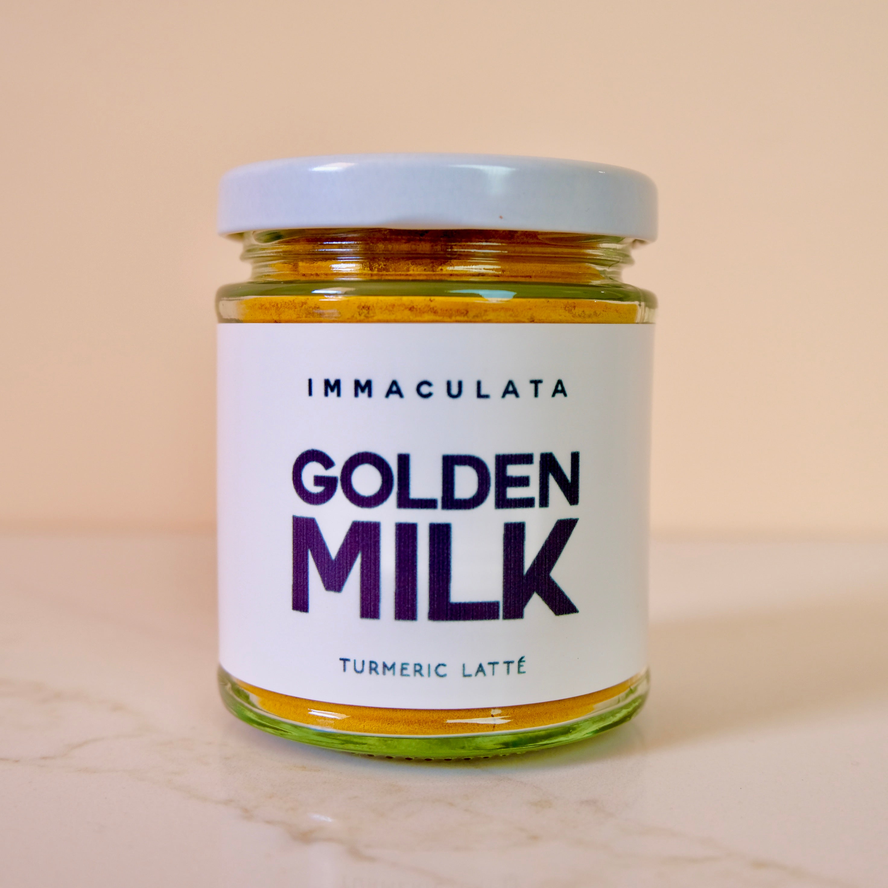 Jar of Immaculata Golden Milk Turmeric Latté on a beige background