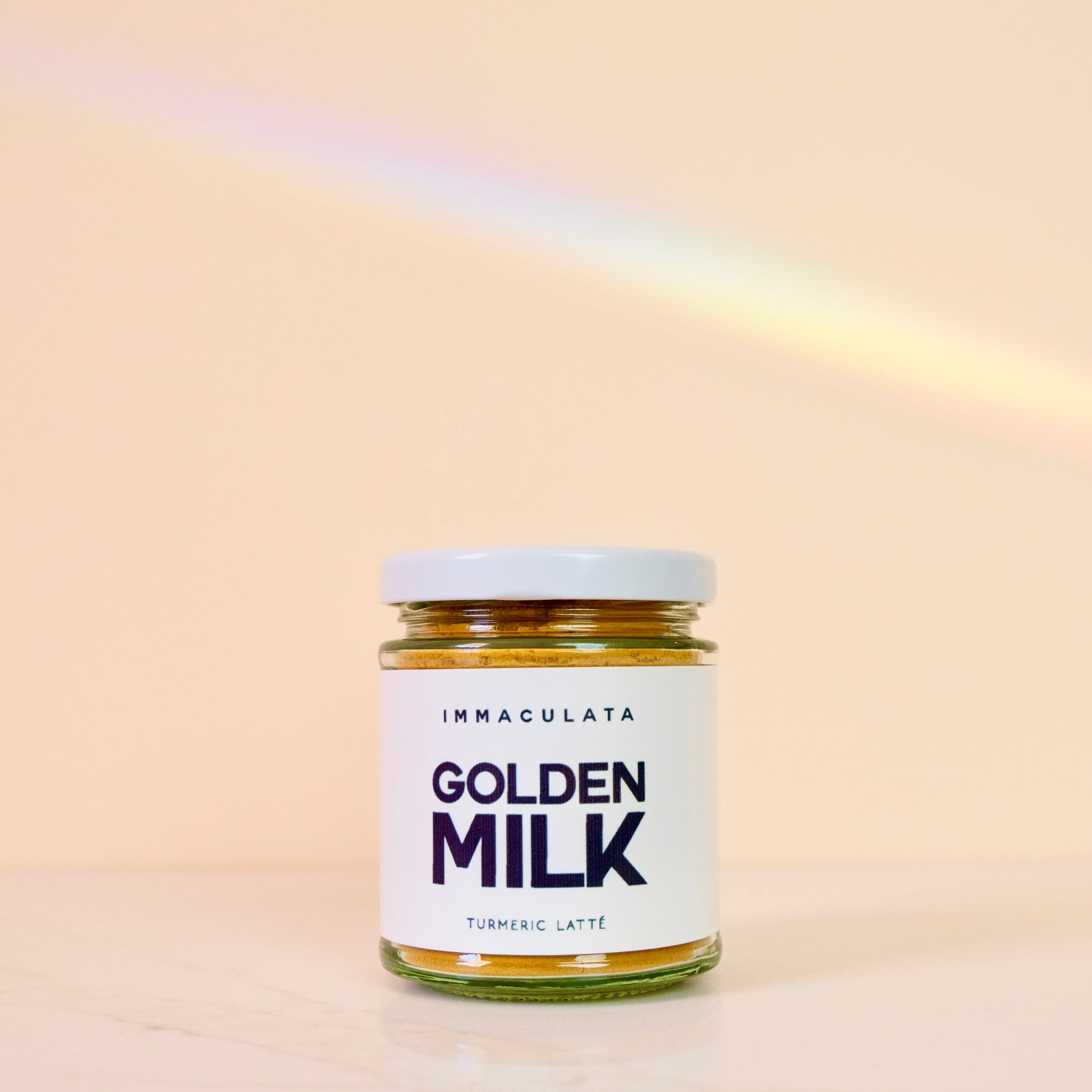 Jar of Immaculata Golden Milk Turmeric Latte on a beige background