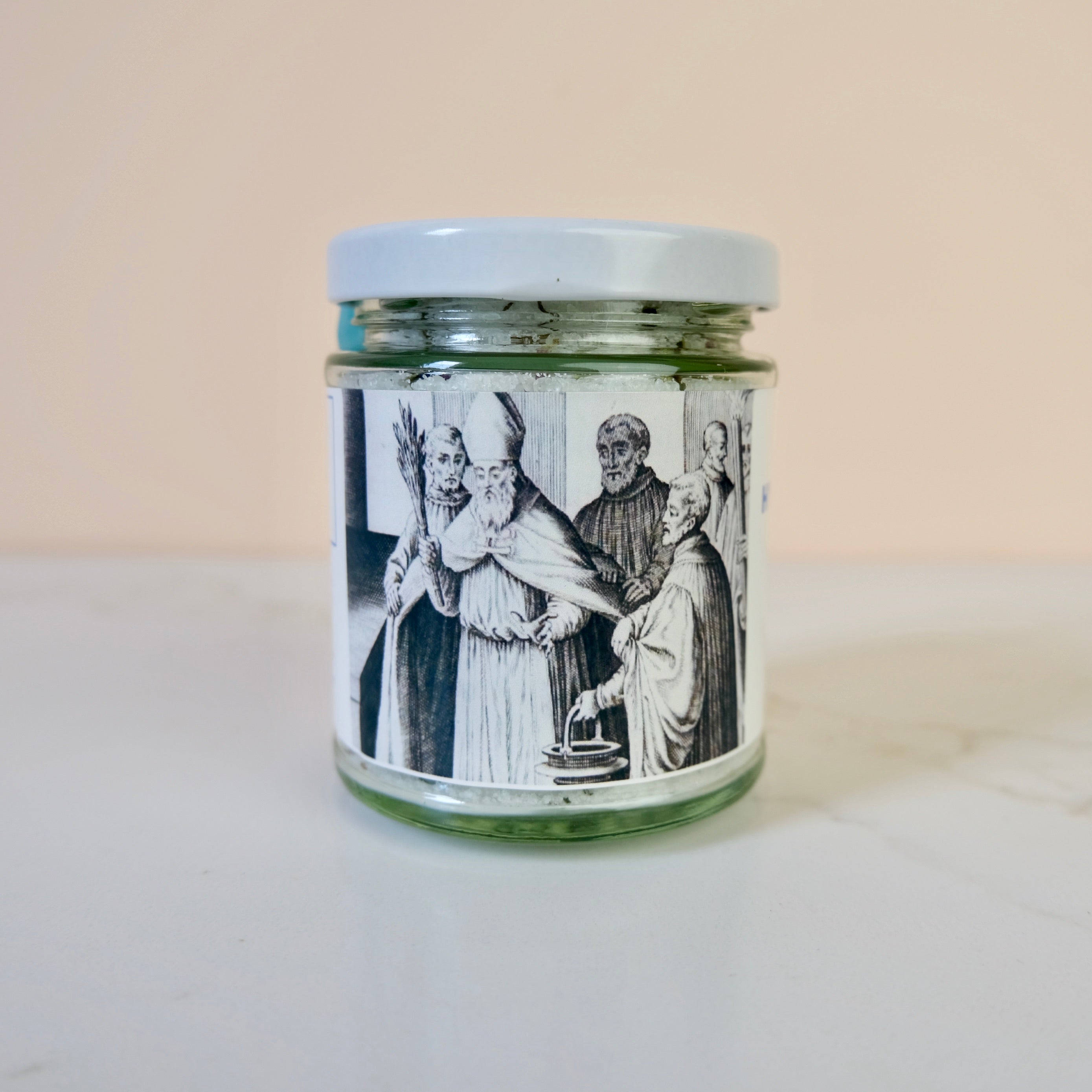 Glass jar with a printed label featuring historical figures on a white surface.