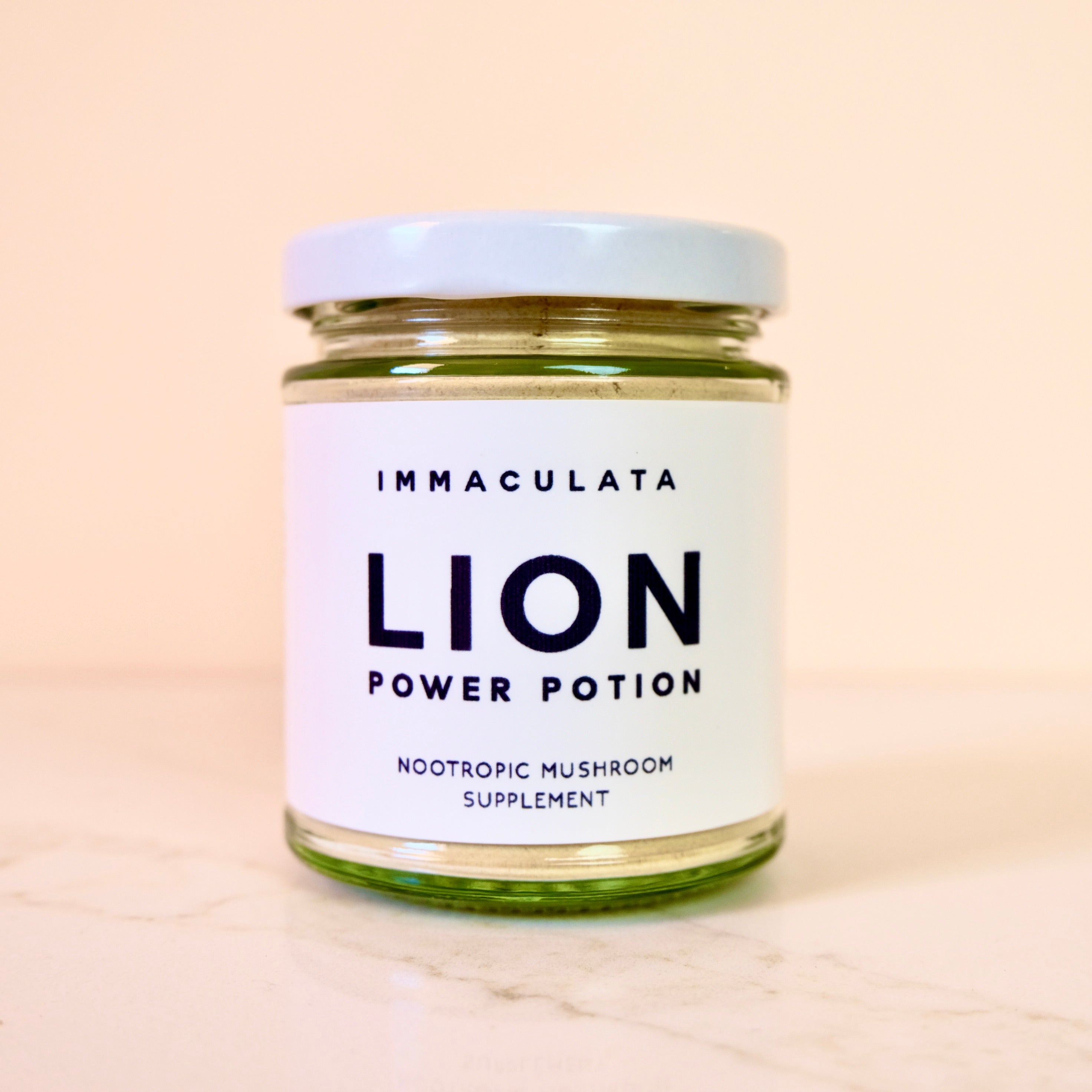 Glass jar labeled 'Immaculata Lion Power Potion' on a beige background