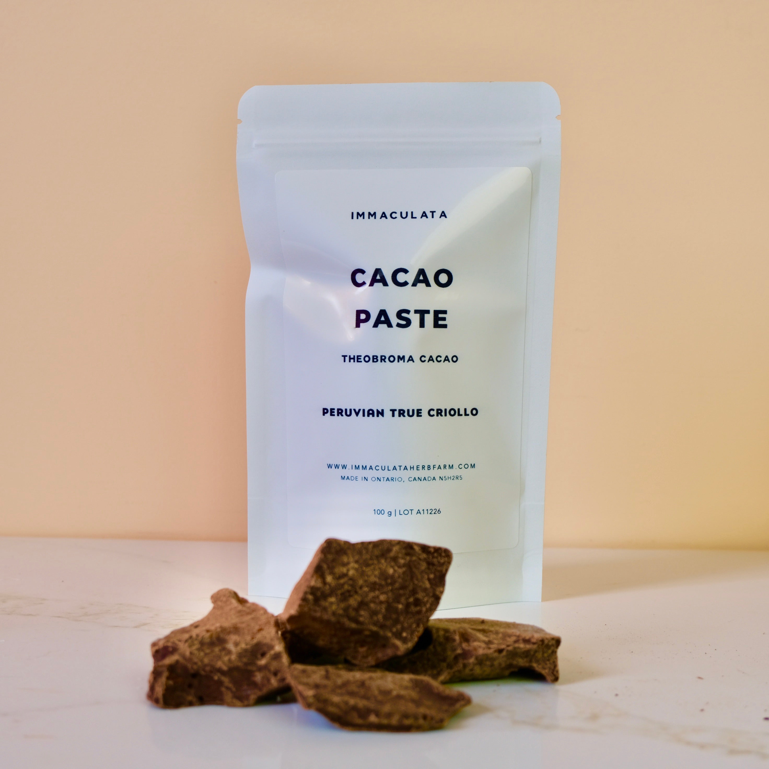 Package of Immaculata Cacao Paste with cacao pieces on a beige background