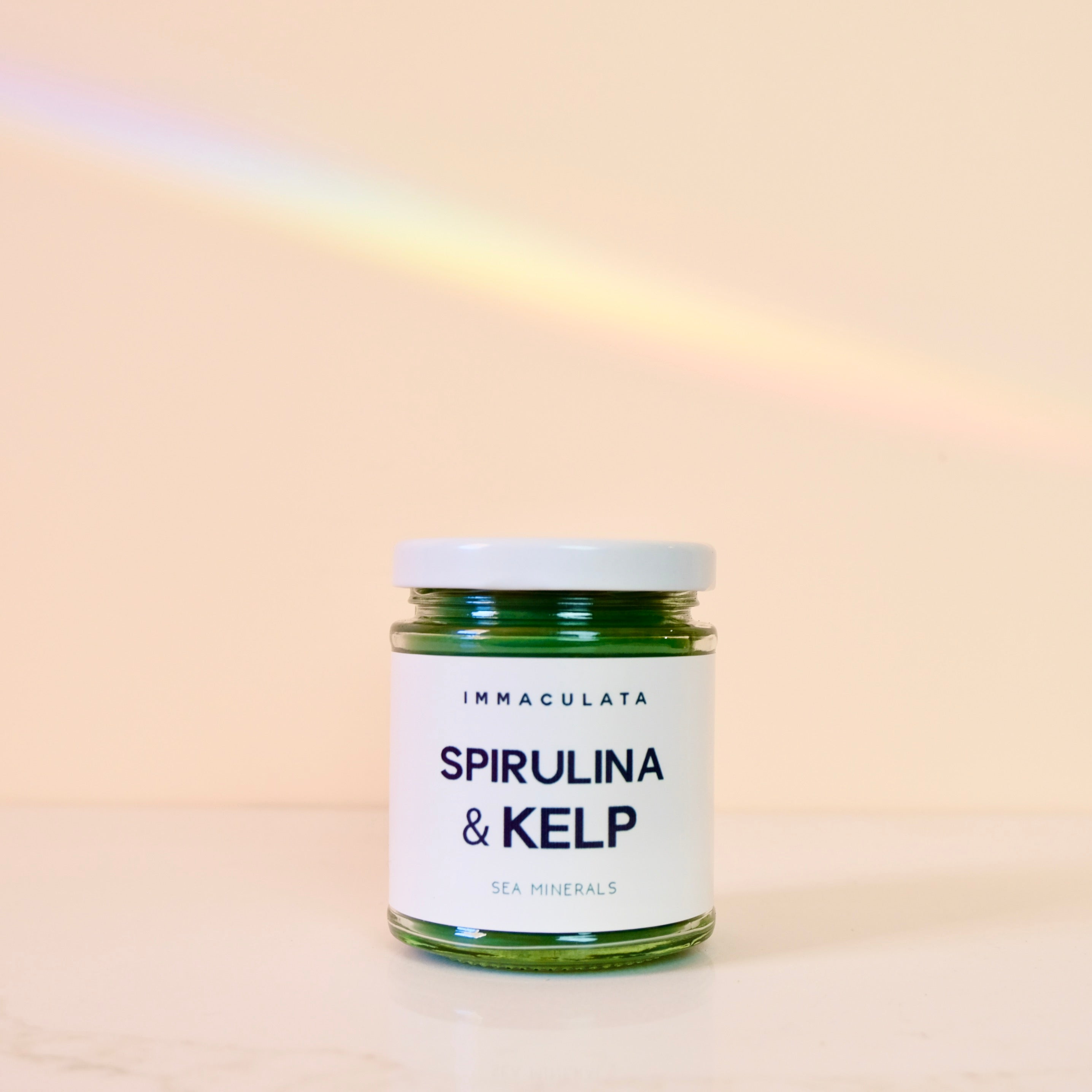 Jar of Spirulina & Kelp product with 'Immaculata' label on a beige background