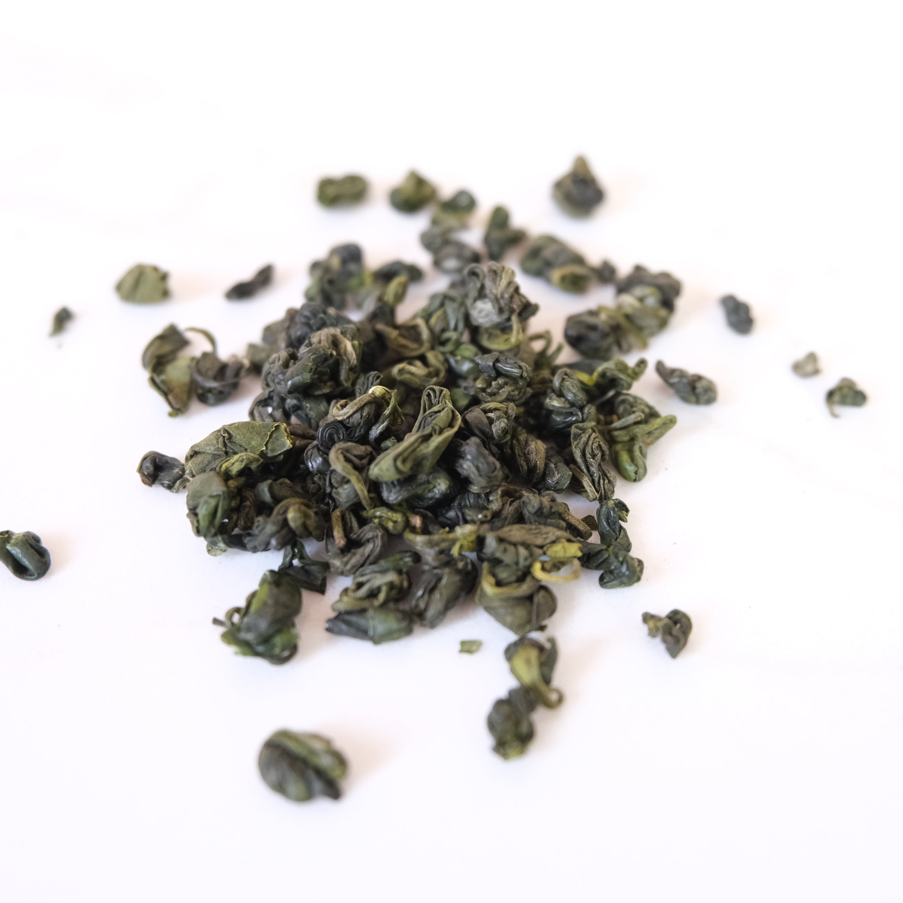 Dry green tea leaves on a white background