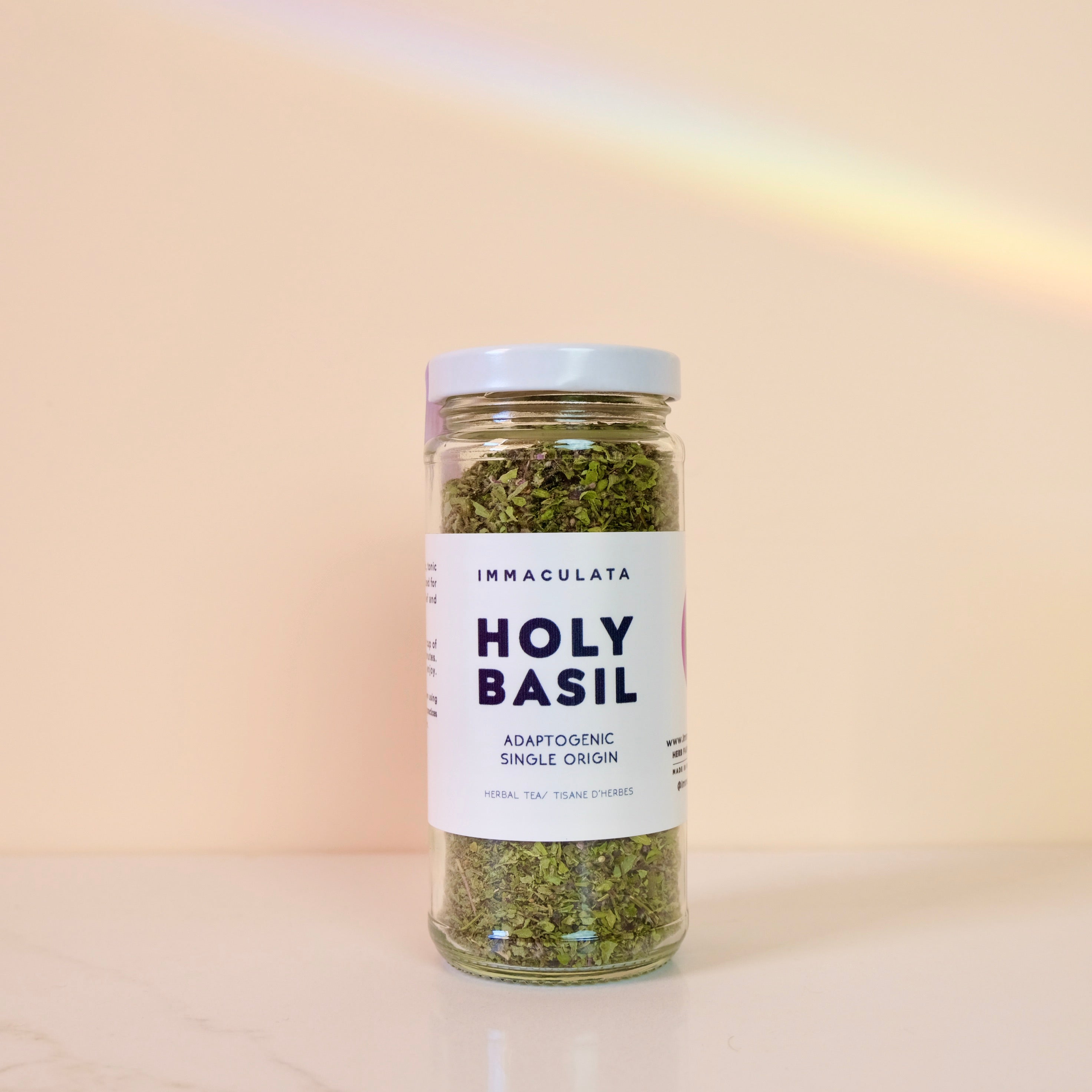 Jar of holy basil from Immaculata Herb Farm with a label on a beige background