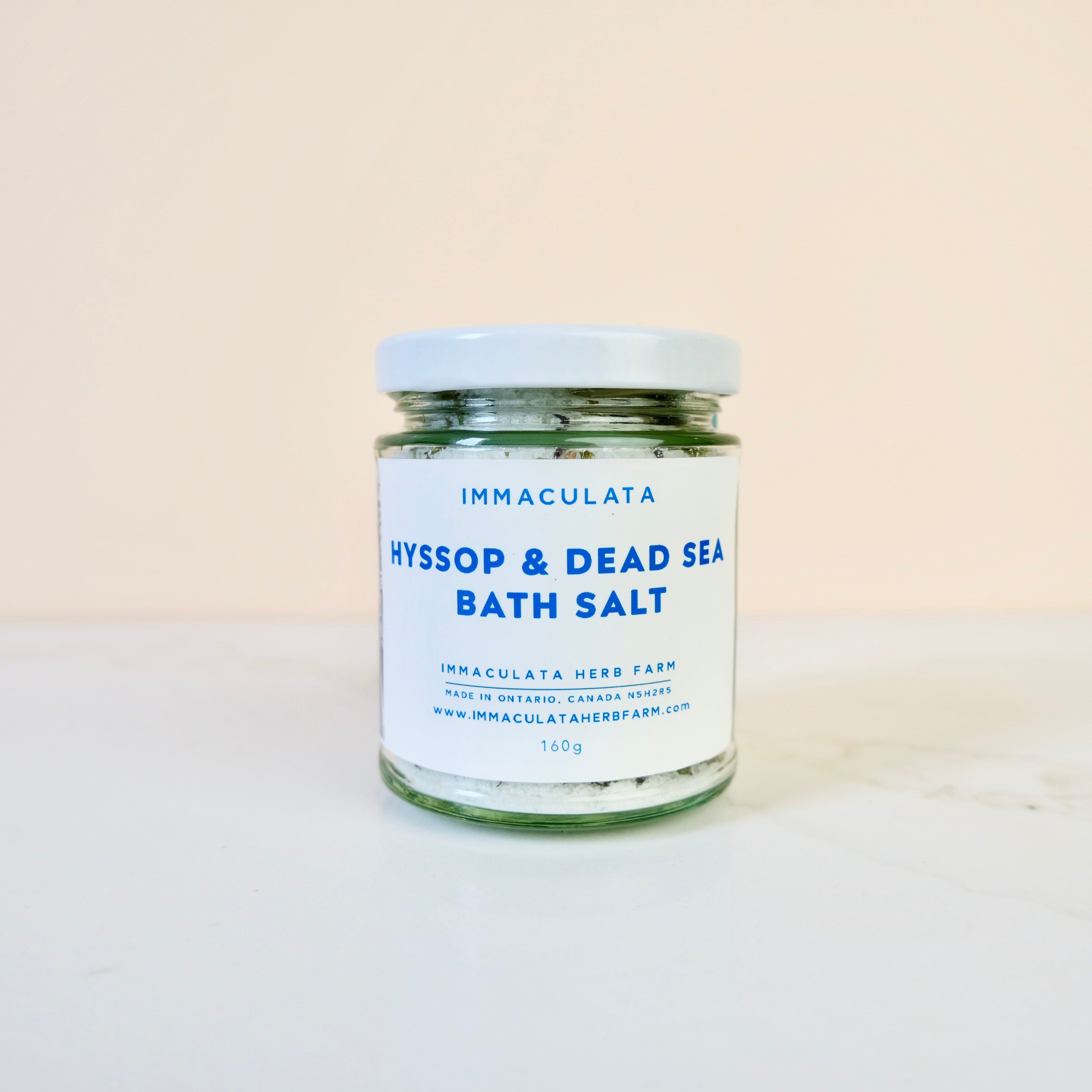Jar of hyssop and Dead Sea bath salt with 'Immaculata' branding on a beige background