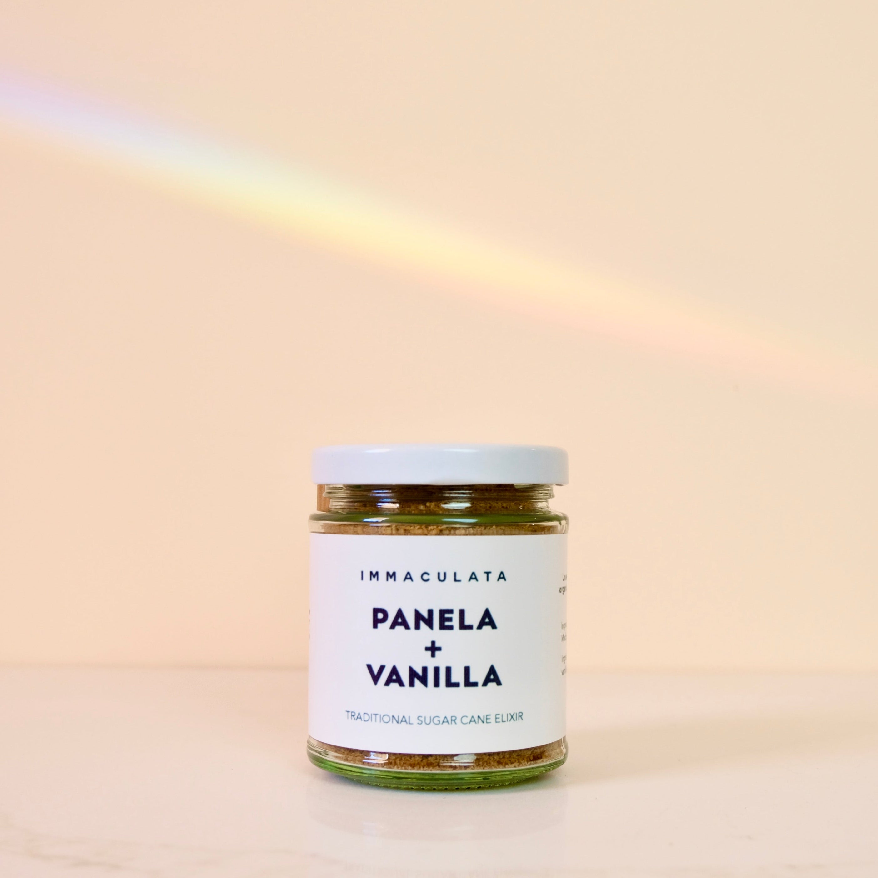 Jar of panela and vanilla by Immaculata Herb Farm on a beige background