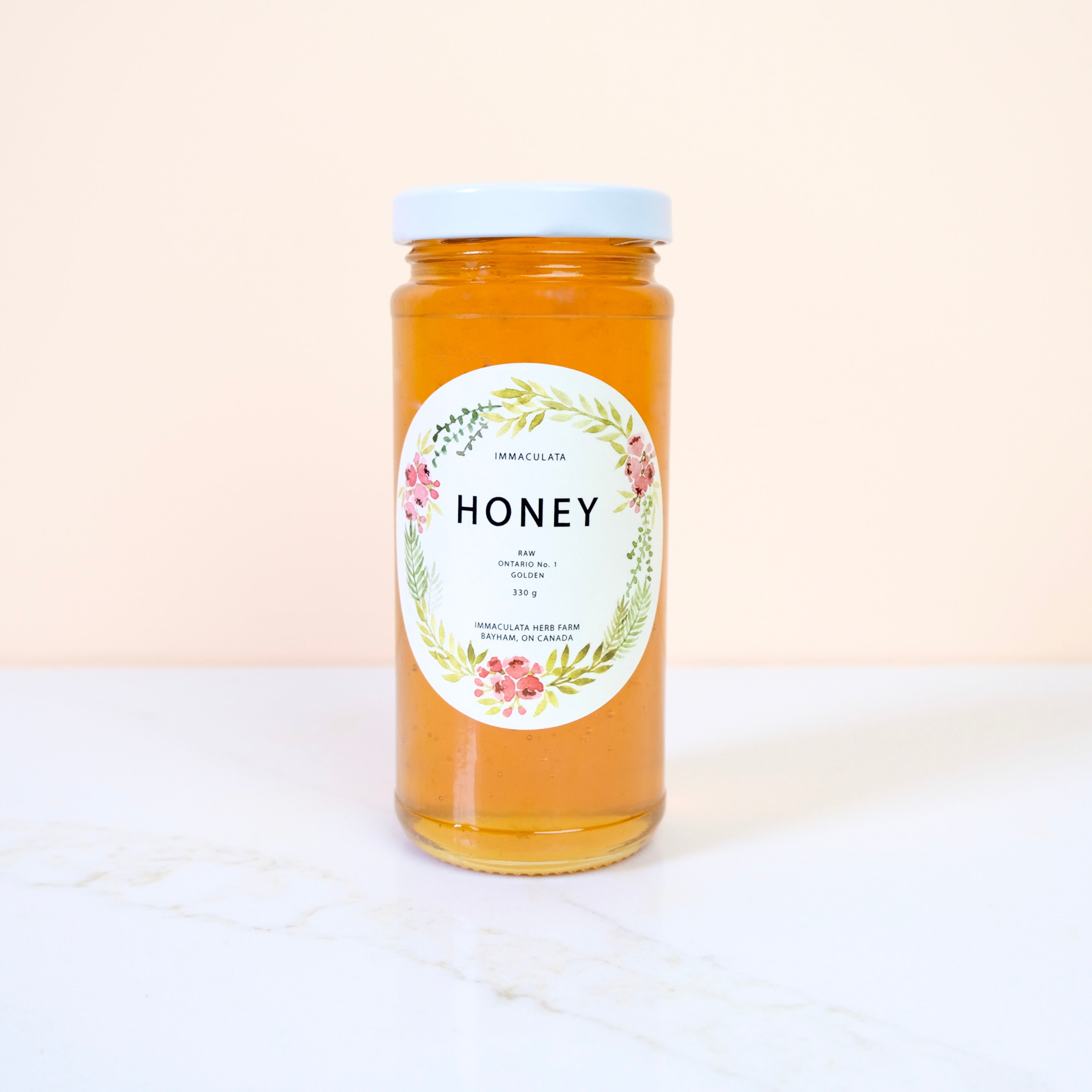 Jar of honey with a decorative label on a white background