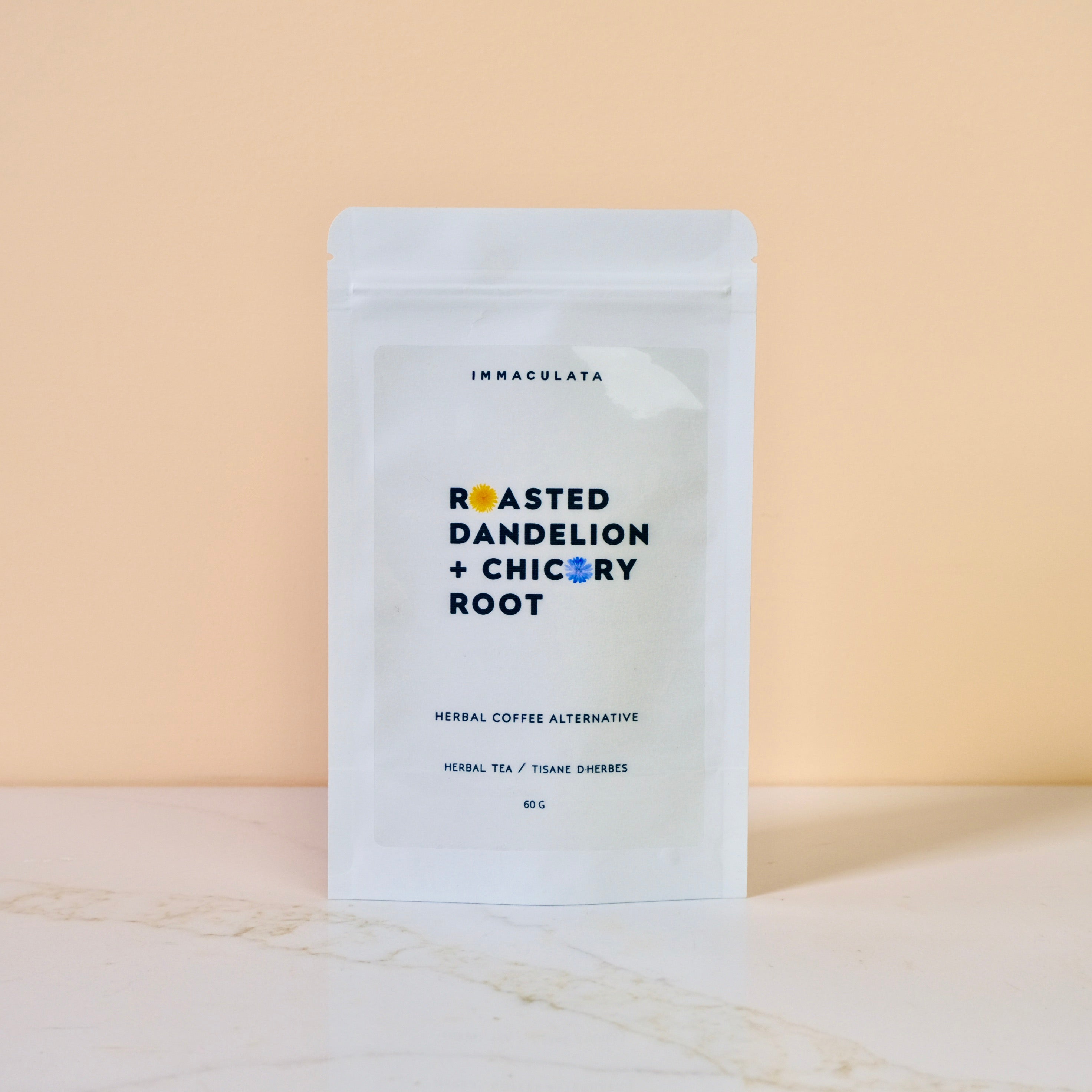 Tea package labeled 'Roasted Dandelion + Chicory Root' by Immaculata on a beige background