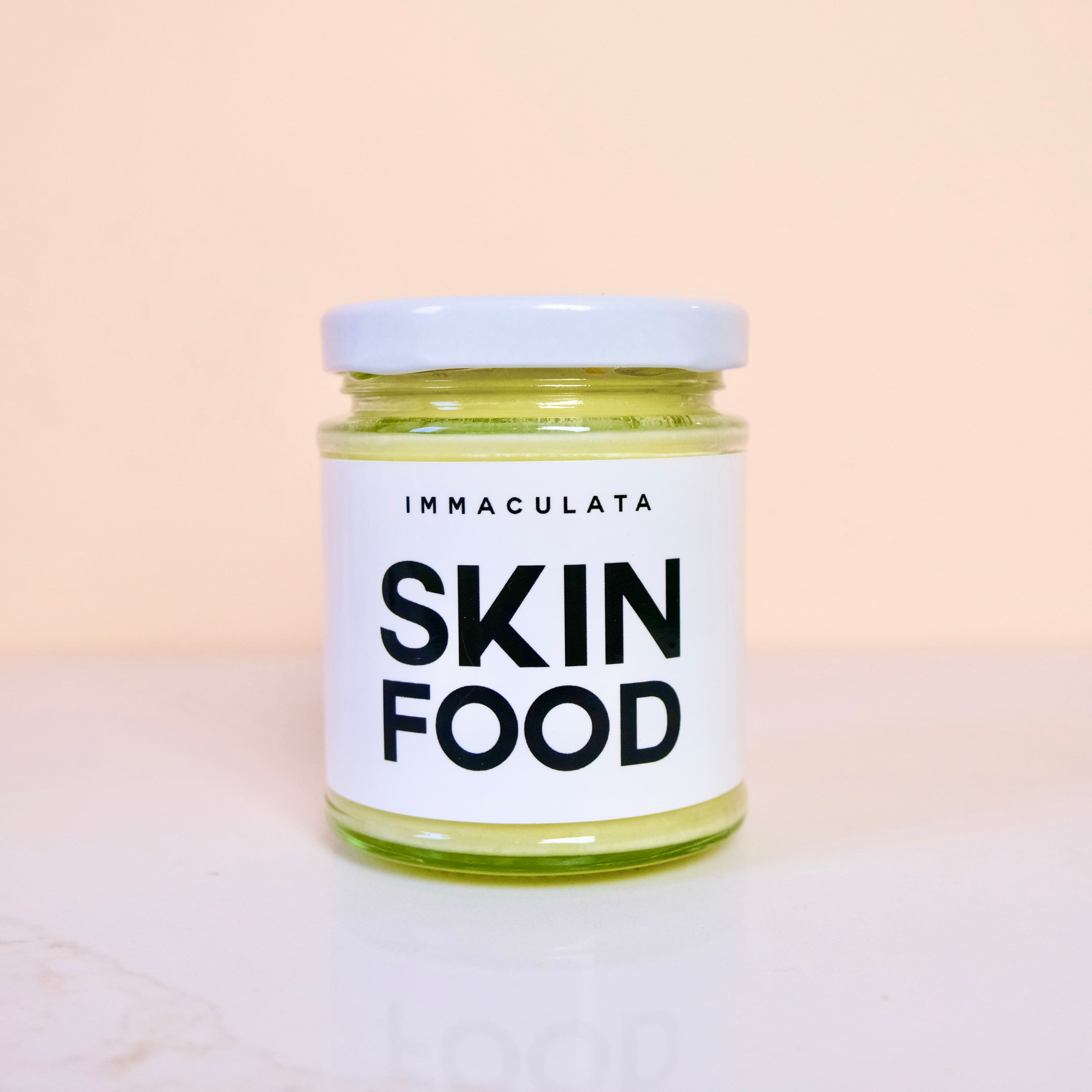 Jar of 'IMMACULATA Skin Food' on a light background
