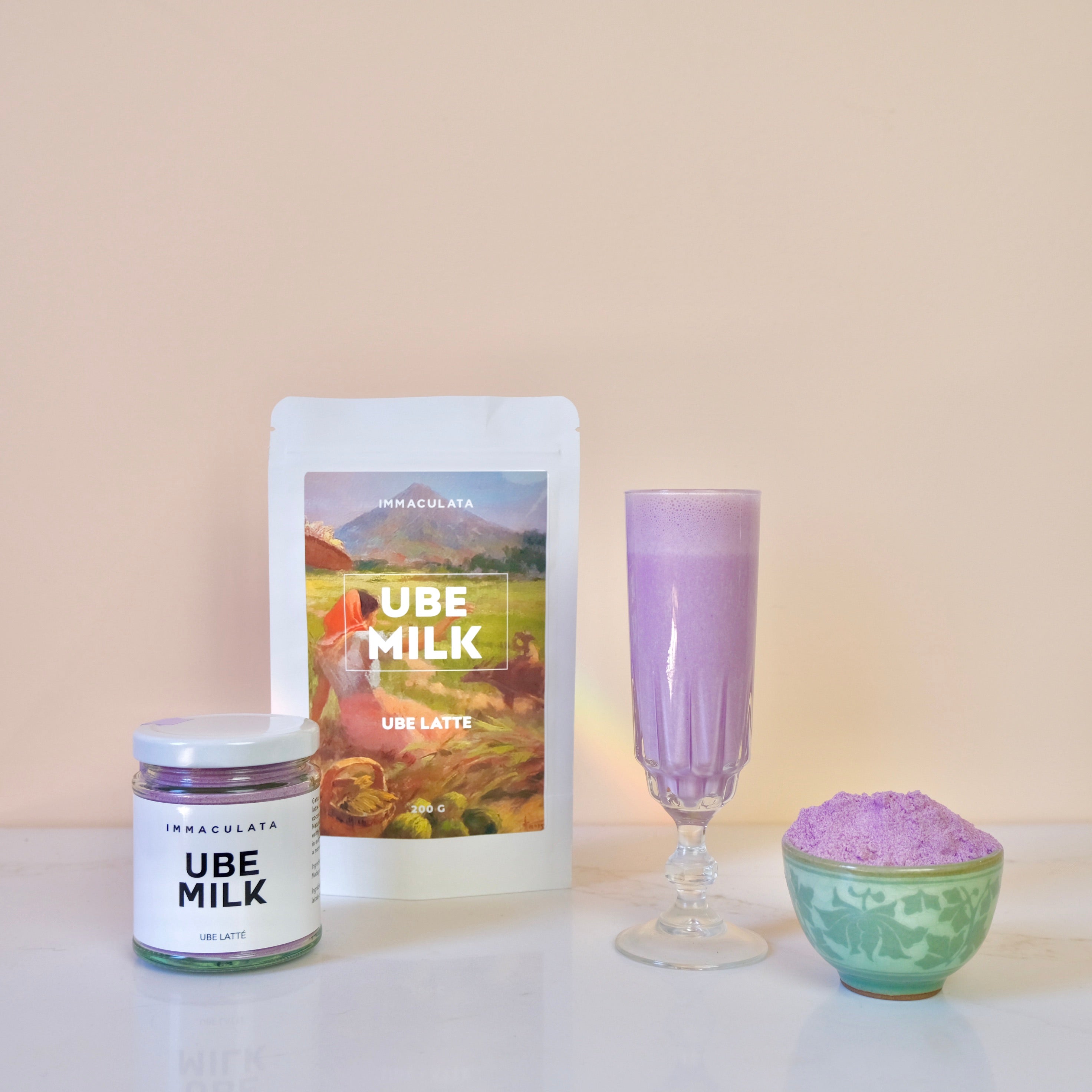 Ube milk products including a jar, pouch, and glass on a light background